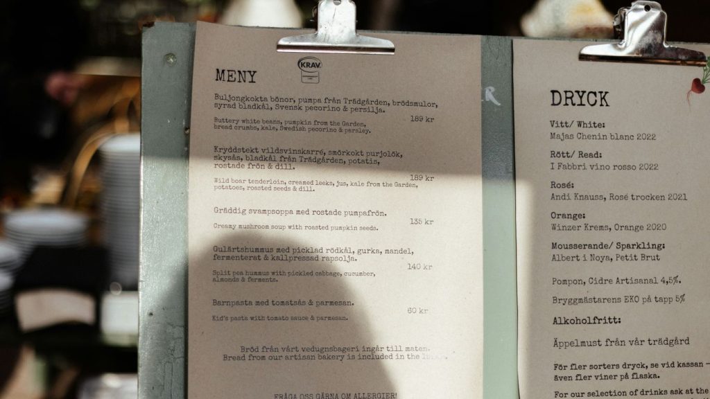 A menu sitting on top of a table next to a cup of coffee