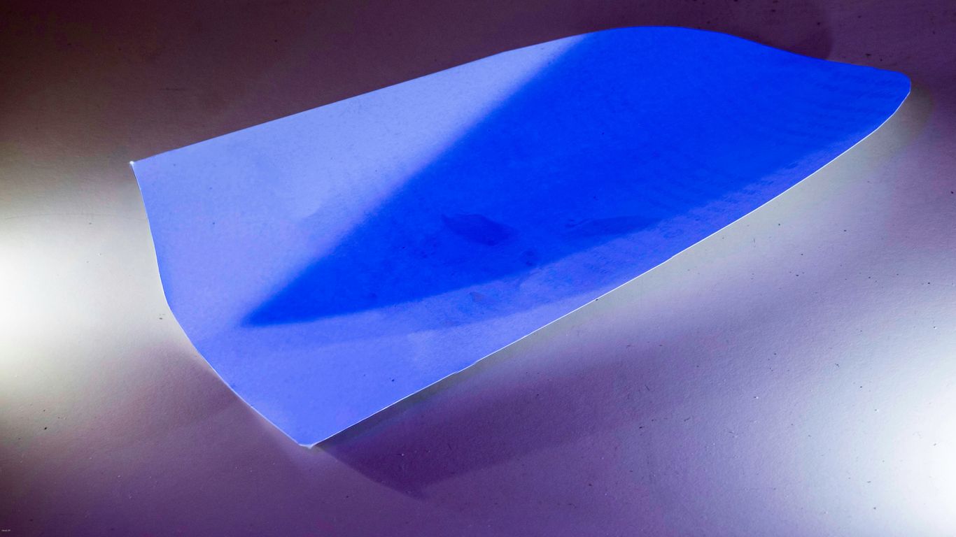 A bright blue abstract shape with shadows.