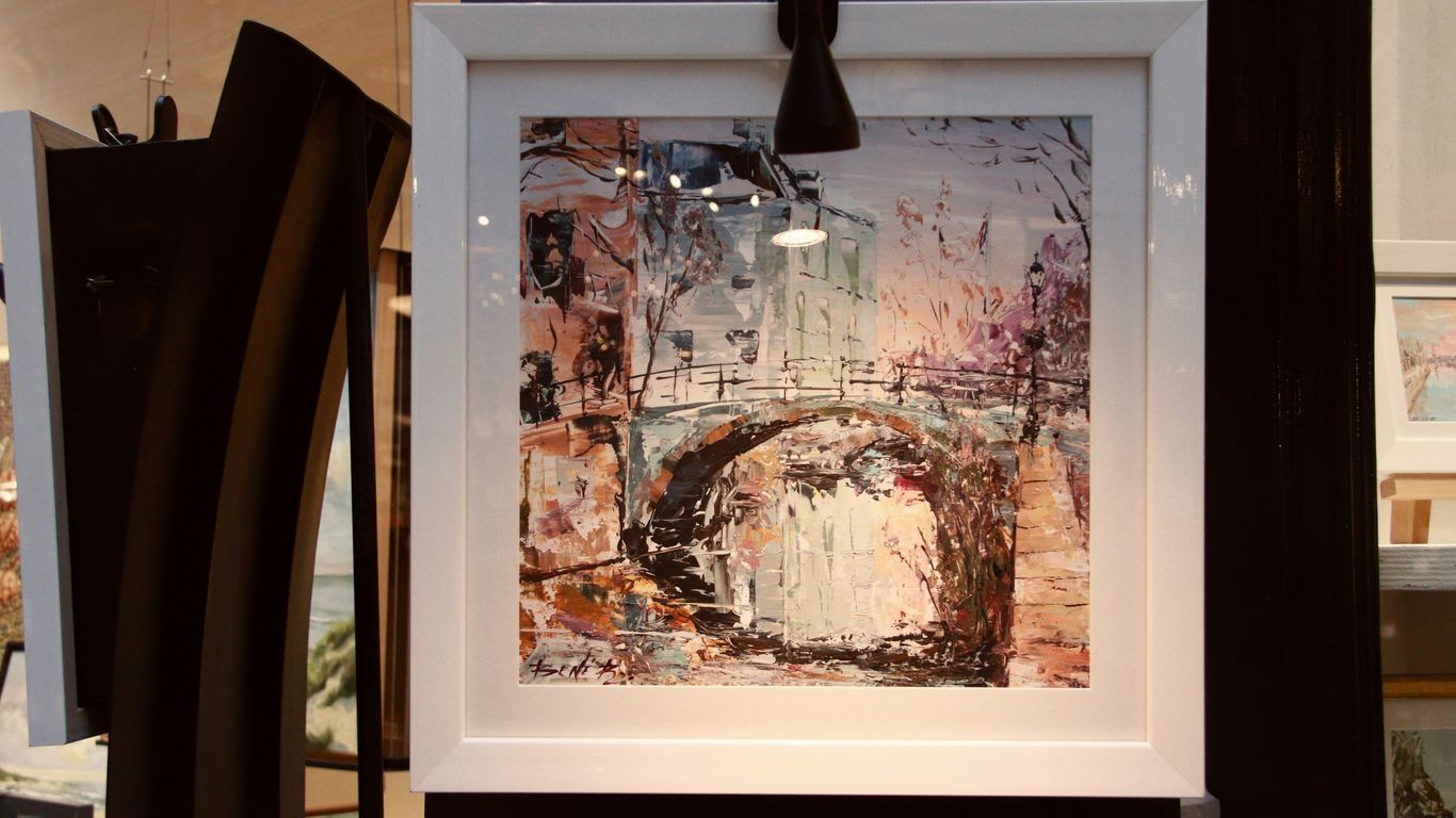 Framed abstract painting with a bridge.
