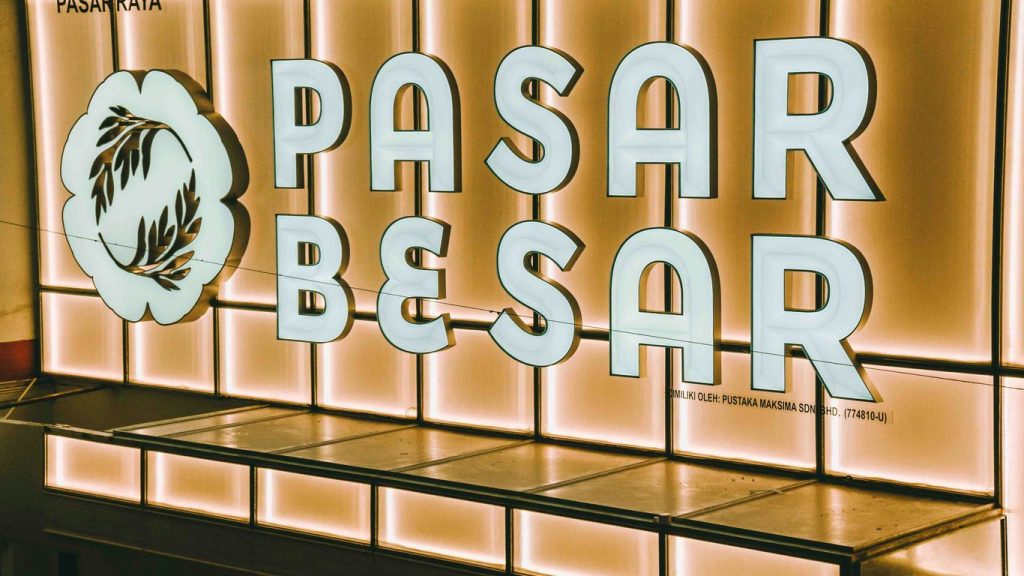 Pasar besar sign illuminated with warm light.